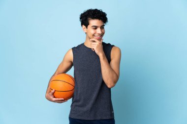 Venezuelalı basketbolcu, izole bir arka planda, yana bakıyor ve gülümsüyor.