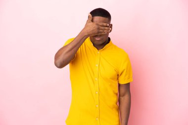 Pembe arka planda izole edilmiş genç latin adam gözlerini elleriyle kapatıyor. Bir şey görmek istemiyorum.