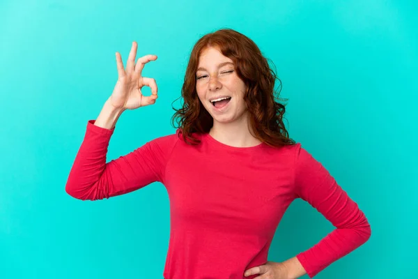 Genç Kızılımsı Kadın Mavi Arka Planda Izole Edilmiş Parmaklarıyla Işaret — Stok fotoğraf