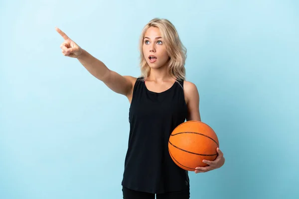 Jong Russisch Vrouw Spelen Basketbal Geïsoleerd Blauwe Achtergrond Wijzend Weg — Stockfoto