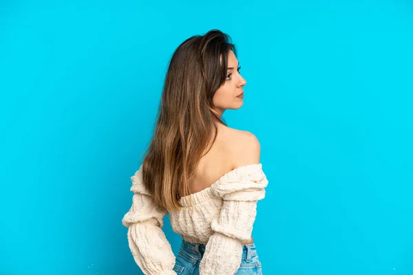 Junge Kaukasische Frau Isoliert Auf Blauem Hintergrund Rückenlage Und Blickt — Stockfoto
