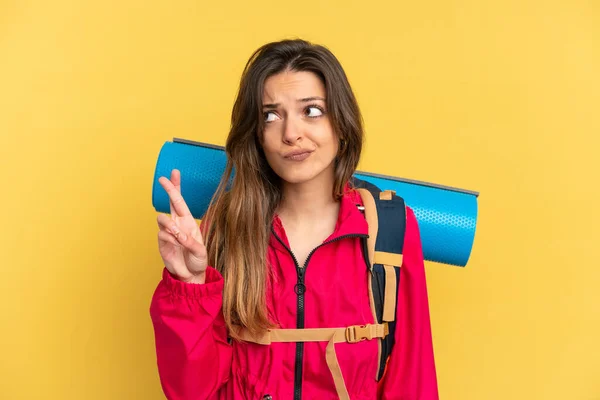 Young Mountaineer Man Big Backpack Isolated Yellow Background Fingers Crossing —  Fotos de Stock