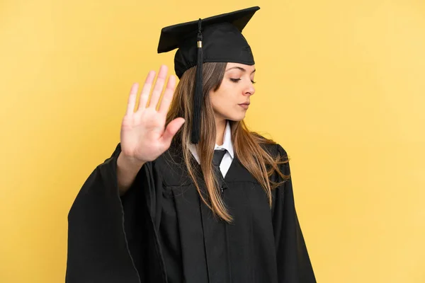 Junger Universitätsabsolvent Isoliert Auf Gelbem Hintergrund Macht Stop Geste Und — Stockfoto