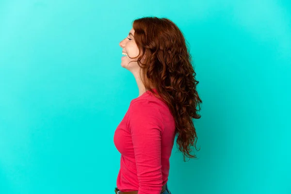 Teenager Načervenalé Žena Izolované Modrém Pozadí Směje Laterální Poloze — Stock fotografie