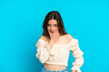 Kafkasyalı genç bir kadın mavi arka planda soyutlanmış düşünüyor.