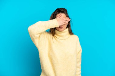 Mavi arka planda, gözleri elle kaplanmış beyaz bir kadın. Bir şey görmek istemiyorum.