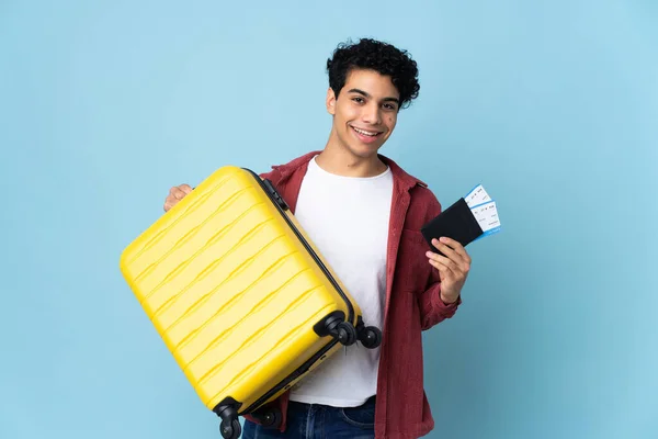 Jonge Venezolaanse Man Geïsoleerd Blauwe Achtergrond Vakantie Met Koffer Paspoort — Stockfoto