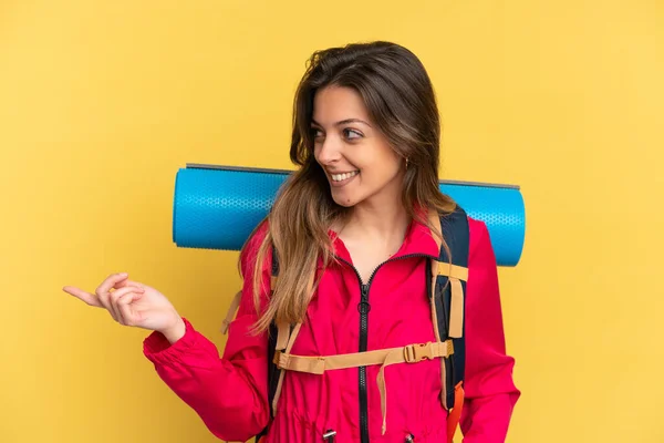 Young Mountaineer Man Big Backpack Isolated Yellow Background Pointing Finger — ストック写真