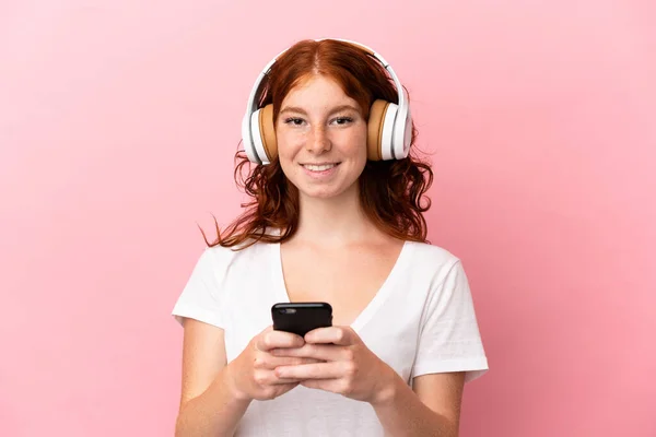 Tinédzser Vöröses Elszigetelt Rózsaszín Háttér Hallgat Zenét Egy Mobil Néz — Stock Fotó