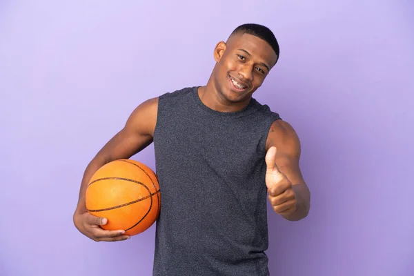 年轻的篮球选手 背负紫色背景 竖起大拇指 因为发生了一些好事 — 图库照片