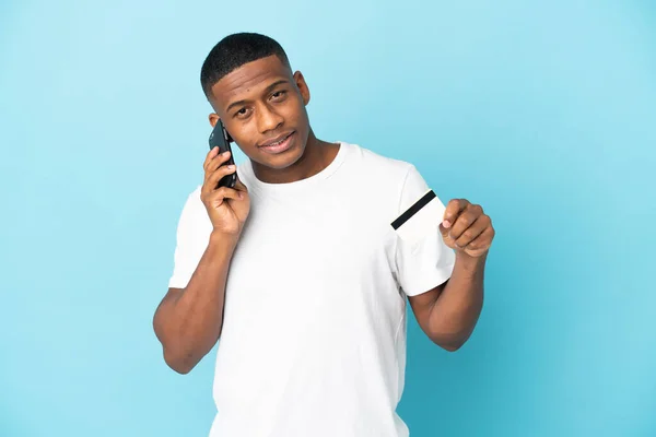 Joven Latino Aislado Sobre Fondo Azul Manteniendo Una Conversación Con —  Fotos de Stock