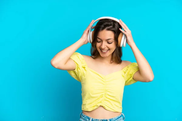 Joven Mujer Caucásica Aislada Sobre Fondo Azul Escuchando Música —  Fotos de Stock