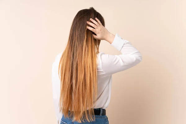 Mujer Joven Caucásica Aislada Sobre Fondo Beige Posición Espalda Pensando —  Fotos de Stock