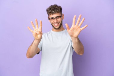 Mor arka planda izole edilmiş beyaz adam dokuz parmaklı sayıyor.