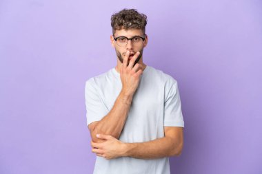 Mor arka planda izole edilmiş beyaz adam sağa bakarken şaşırmış ve şok olmuş.