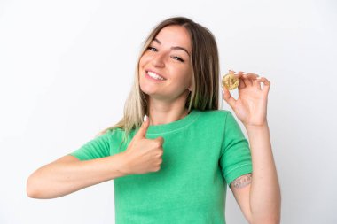 İyi bir şey olduğu için beyaz arka planda izole edilmiş bir Bitcoin tutan genç Romen kadını