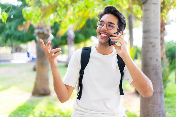 Młody Student Świeżym Powietrzu Pomocą Telefonu Komórkowego — Zdjęcie stockowe