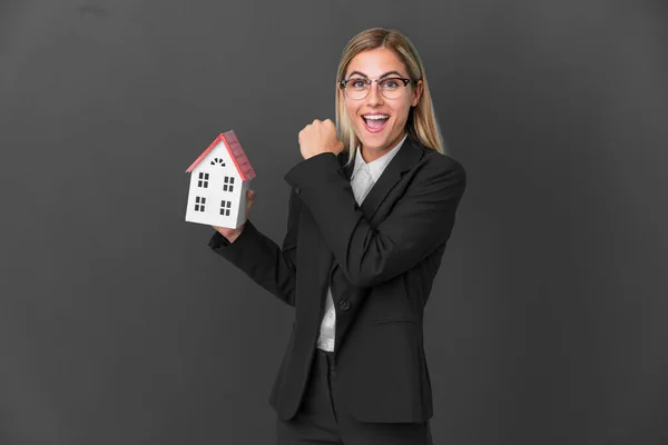 Blonde Uruguayan Girl Holding House Toy Isolated Black Background Celebrating — Stock Photo, Image