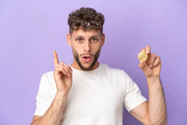 Junger Kaukasischer Mann Hält Einen Bitcoin Isoliert Auf Violettem Hintergrund — Stockfoto
