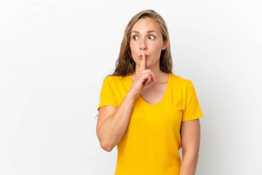 Beyaz arka planda izole edilmiş beyaz bir kadın sessiz bir jest işareti gösteriyor. Parmağını ağzına sokuyor.