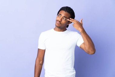 Örgülü genç Afrikalı Amerikalı adam mor arka planda izole edilmiş ve intihar jesti yapmada sorun yaşıyor.