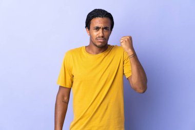 Örgülü genç Afrikalı Amerikalı adam mutsuz bir ifadeyle mor arka planda izole edildi.