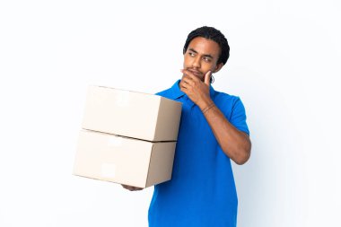 Beyaz arka planda örgü örüp gülümseyen Afro-Amerikan bir adam.