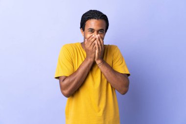 Örgülü genç Afrikalı Amerikalı adam mor arka planda izole edilmiş mutlu ve gülümseyen elleriyle ağzını kapatıyor.