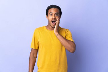 Örgülü genç Afrikalı Amerikalı adam, mor arka planda şaşırmış ve şok olmuş bir yüz ifadesiyle izole edilmiş.