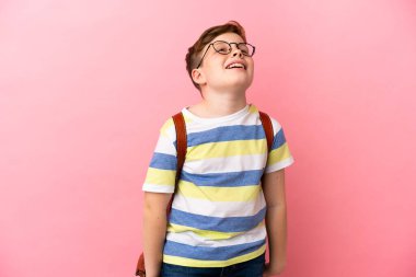 Küçük kızıl saçlı beyaz çocuk pembe arka planda izole edilmiş gülüyor.