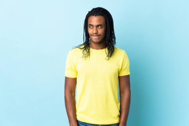 Beyaz arka planda örgü ören Afrikalı Amerikalı bir adamın yukarı bakarken kuşkuları var.