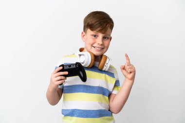 Küçük kızıl saçlı çocuk beyaz arka planda izole edilmiş bir oyun sahası tutuyor.