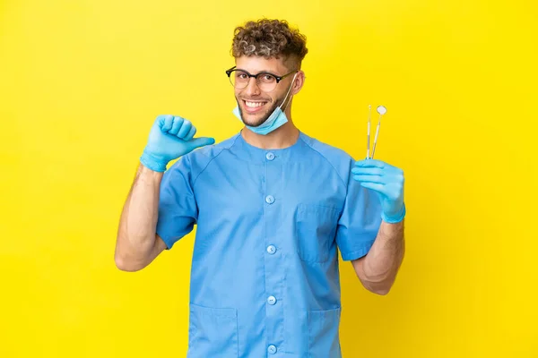 Dentista Loira Homem Segurando Ferramentas Isoladas Fundo Orgulhoso Auto Satisfeito — Fotografia de Stock