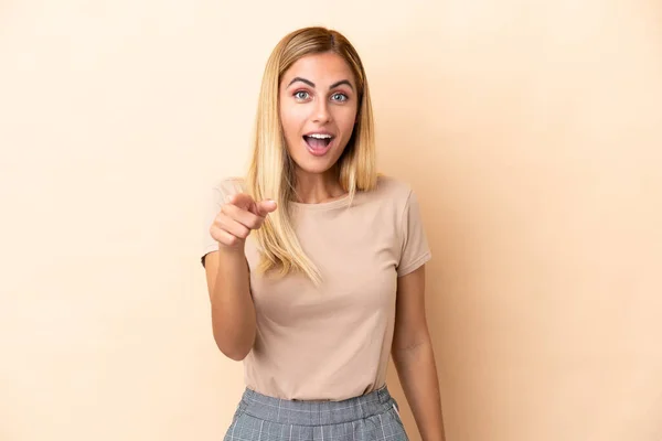 Loira Uruguaia Menina Isolada Fundo Bege Surpreso Apontando Frente — Fotografia de Stock