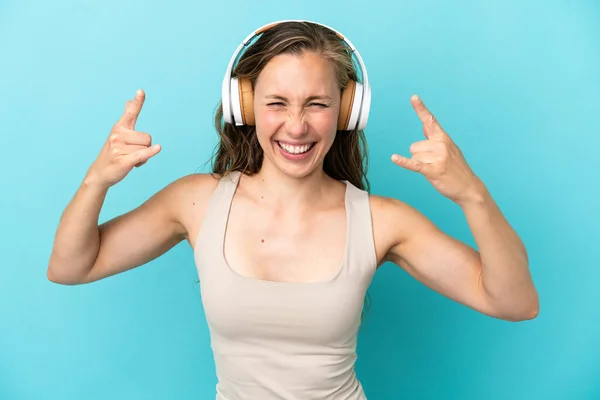 Joven Mujer Caucásica Aislada Sobre Fondo Azul Escuchando Música Haciendo —  Fotos de Stock