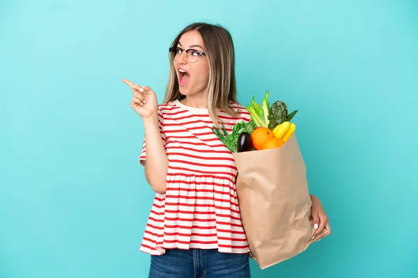 Jonge Vrouw Met Een Boodschappentas Geïsoleerd Blauwe Achtergrond Van Plan — Stockfoto