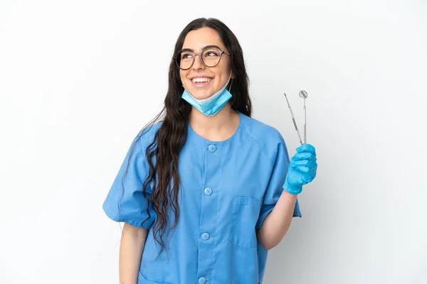 Młoda Kobieta Dentysta Trzyma Narzędzia Izolowane Białym Tle Myśląc Pomysł — Zdjęcie stockowe