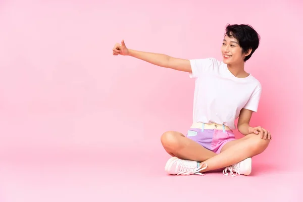 Young Vietnamese Woman Short Hair Sitting Floor Isolated Pink Background — Stock Photo, Image