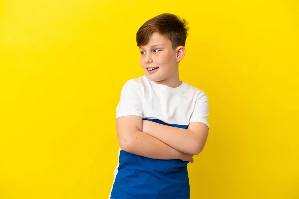 黄色の背景に孤立した小さな赤毛の男の子幸せと笑顔 — ストック写真