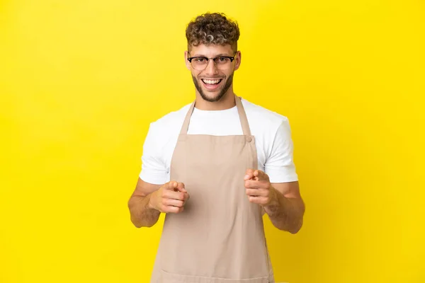 Restauracja Kelner Blondynka Człowiek Izolowany Żółtym Tle Wskazując Przód Uśmiechnięty — Zdjęcie stockowe