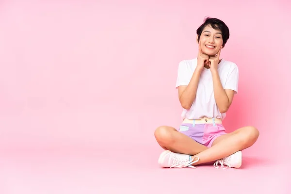 Jovem Vietnamita Com Cabelo Curto Sentado Chão Sobre Fundo Rosa — Fotografia de Stock