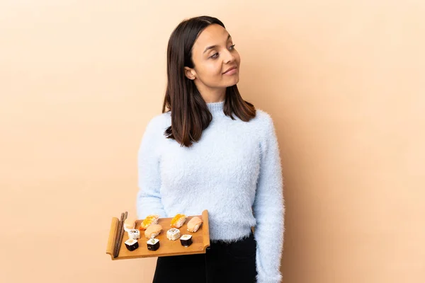 Junge Brünette Frau Mit Gemischter Rasse Hält Sushi Über Isoliertem — Stockfoto