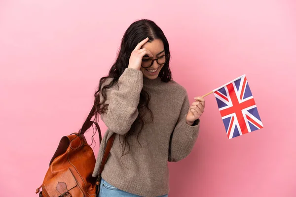 ピンクを背景にイギリス国旗を掲げた若い白人女性が笑っている — ストック写真