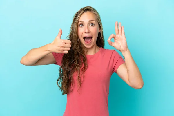 Junge Kaukasische Frau Isoliert Auf Blauem Hintergrund Zeigt Zeichen Und — Stockfoto