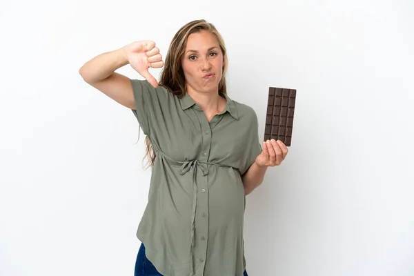若いですCaucasian女性孤立した上に白い背景妊娠と保持チョコレート行う悪い信号 — ストック写真