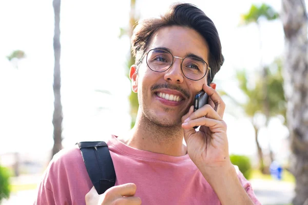 Młody Biały Mężczyzna Zewnątrz Parku Pomocą Telefonu Komórkowego Szczęśliwy Wyraz — Zdjęcie stockowe