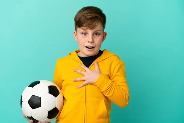 Roodharige Kind Spelen Voetbal Geïsoleerd Blauwe Achtergrond Verrast Geschokt Terwijl — Stockfoto