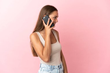 Soyutlanmış pembe bir geçmişi olan genç bir kadın cep telefonuyla sohbet ediyor.