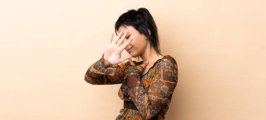 Hindistanlı kadın bej arka planda izole edilmiş gergin eller öne doğru uzanıyor.