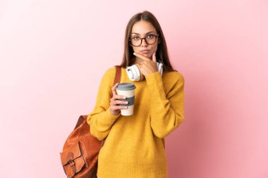 Tecrit edilmiş pembe arka plan düşünen genç bir kız öğrenci.